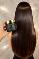 Mulher com cabelo escuro e brilhante segurando a máscara Ouro Marroquino